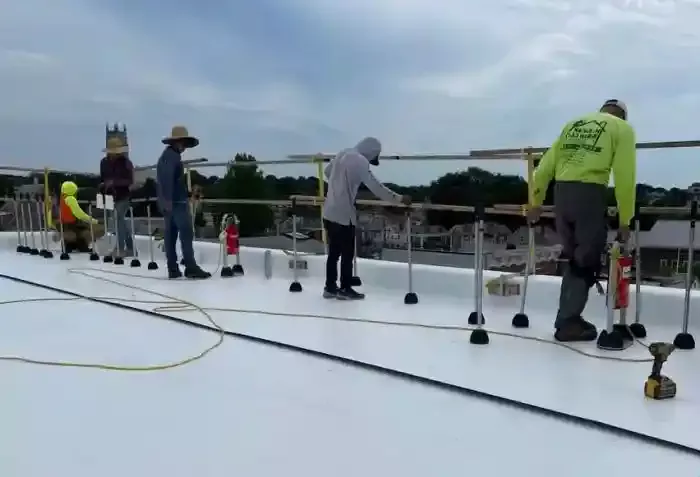H. Kulak & Son LLC contractors working on white commercial rooftop